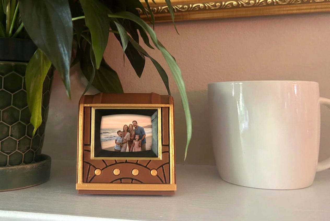 Pict-O-Vision Still on a mantel beside a plant and a mug, screen showing a photograph