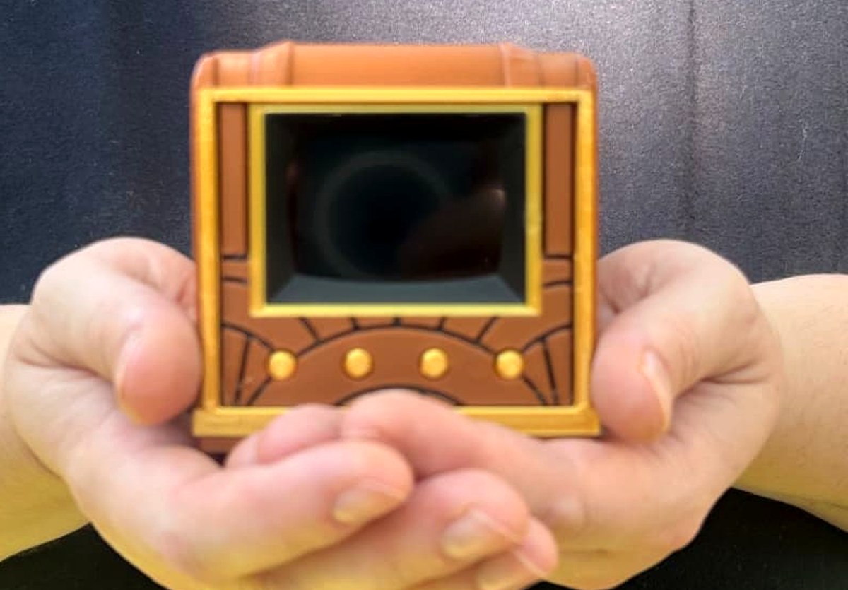 Two hands cradling the Pict-O-Vision Still to show its palm size